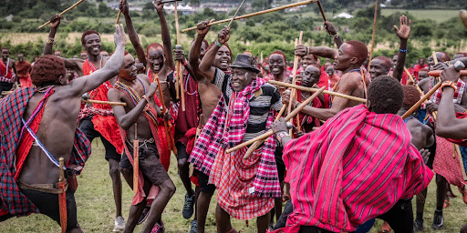 Maasai men performing traditional ceremony maasai-men-in-red-shukas-perform-traditional-ceremony-with-dancing-and-sticks-in-kenya