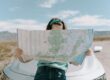 Solo-woman-traveler-reviewing-a-map-on-the-roadside