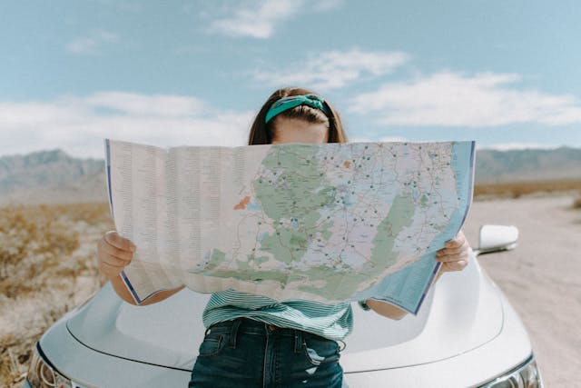 Solo-woman-traveler-reviewing-a-map-on-the-roadside