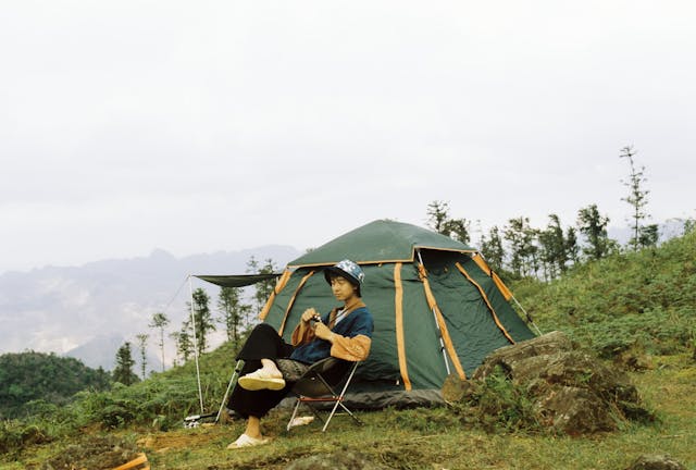 Introvert-traveler-relaxing-at-a-campsite-admiring-a-mountain-view