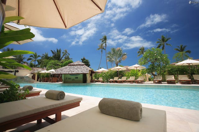 Luxury-lodge-in-Kenya-with-poolside-loungers-and-palm-trees