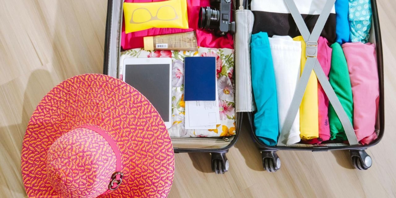 Essential items for women travelers packed in a suitcase, prepared for a trip Essential-items-for-women-travelers-packed -n-a-suitcase-prepared -or-a-trip